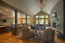 The Living Room features a 16-foot vaulted ceiling with high wall windows plus a stone fireplace with rustic beam mantle.